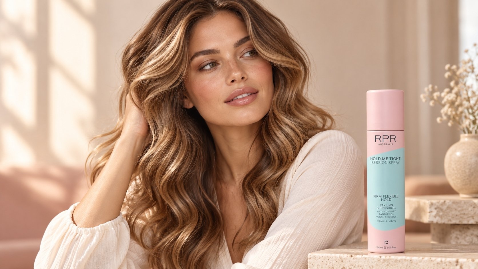 Woman with long, voluminous caramel waves beside RPR Hold Me Tight Session Spray in a soft pastel setting.