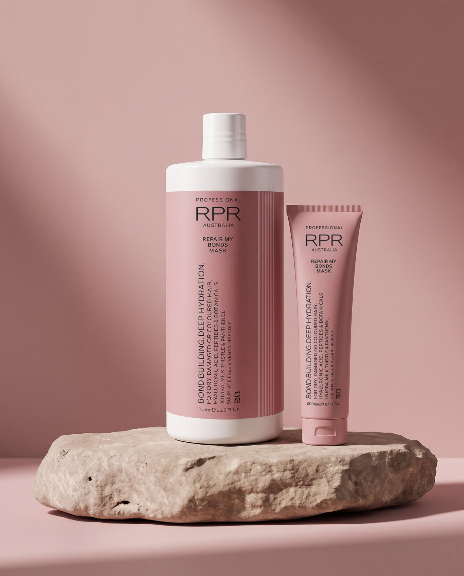 RPR Professional Repair My Bonds Mask in 1 Litre and 200ml sizes, displayed on a stone platform against a soft pink background.